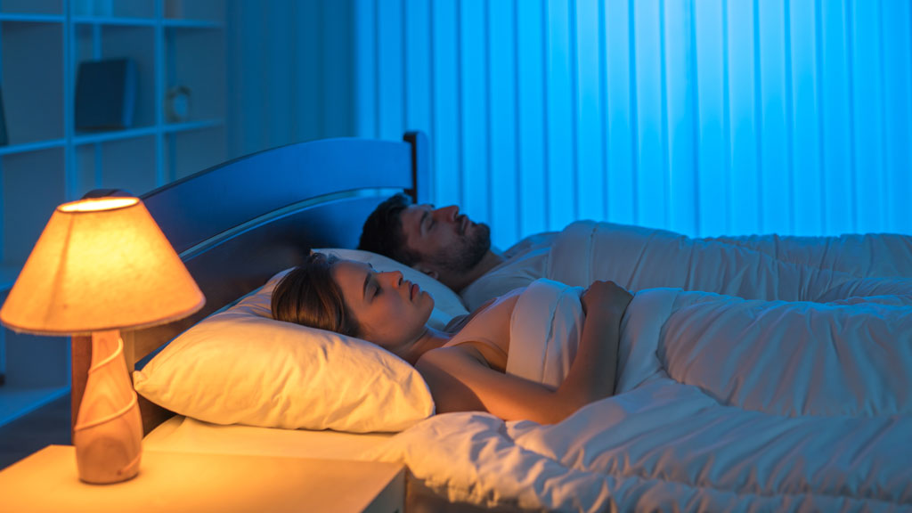 Couple européen dans un lit confortable avec housse de couette bien ajustée dans une chambre cosy